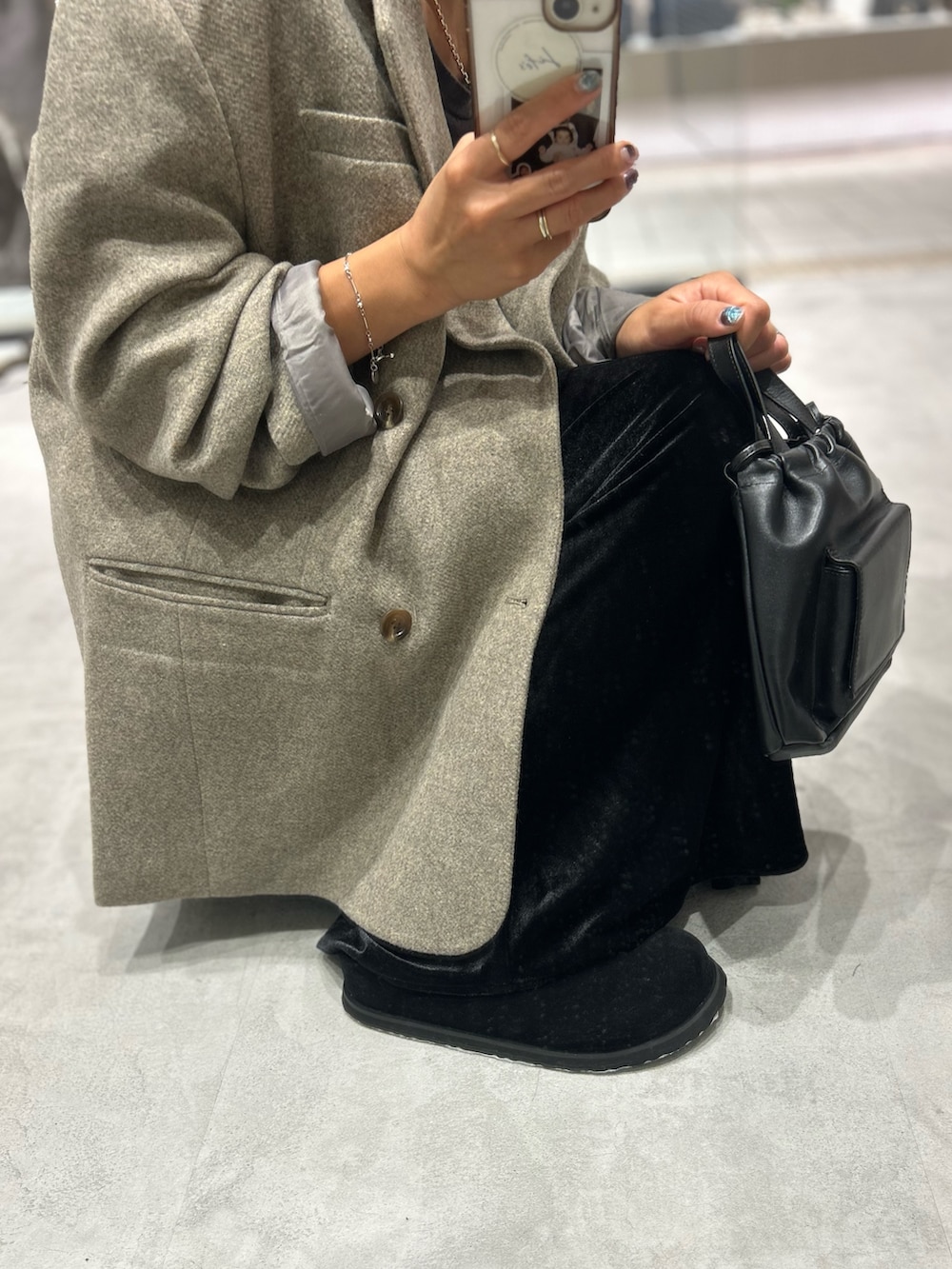 グレー系のテーラードジャケット、ブルー系のTシャツ/カットソー、ブラック系のスカートを着用したレディースの秋コーディネートの6枚目の写真