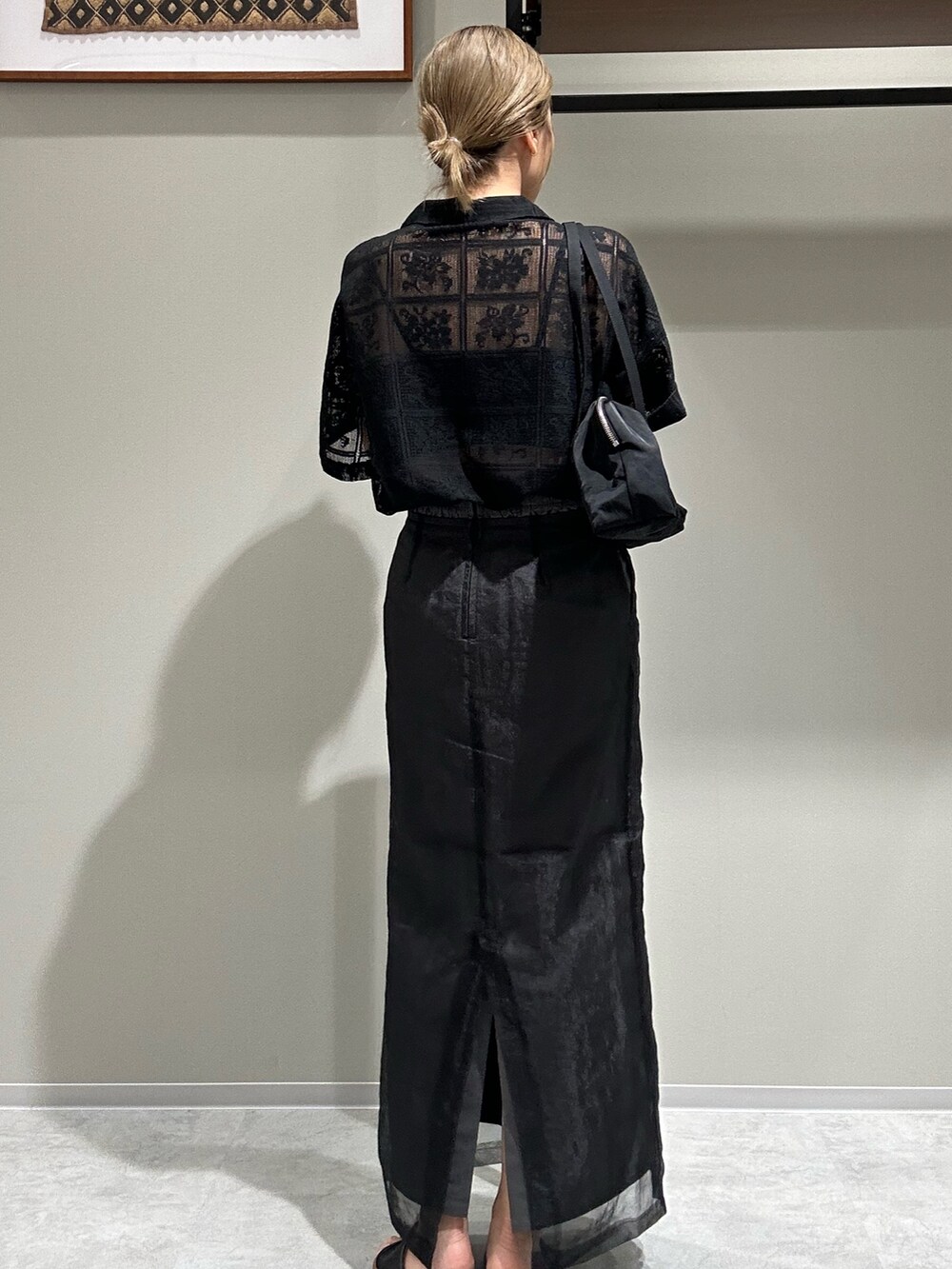 グレー系のスカート、ブラック系のシャツ/ブラウス、ブラック系のハンドバッグを着用したレディースの春コーディネートの3枚目の写真