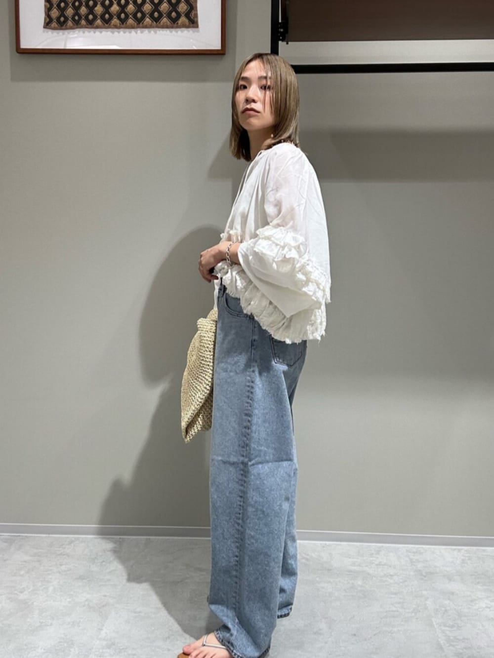 ホワイト系のシャツ/ブラウス、ブルー系のデニムパンツ、シルバー系のサンダルを着用したレディースの春コーディネートの2枚目の写真