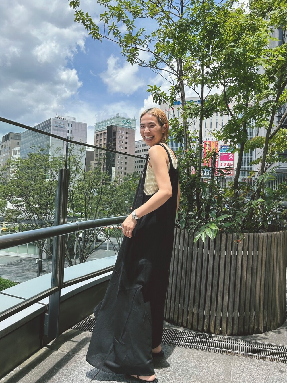 ブラック系のワンピース、イエロー系のTシャツ/カットソー、ブラック系のサンダルを着用したレディースの夏コーディネートの2枚目の写真