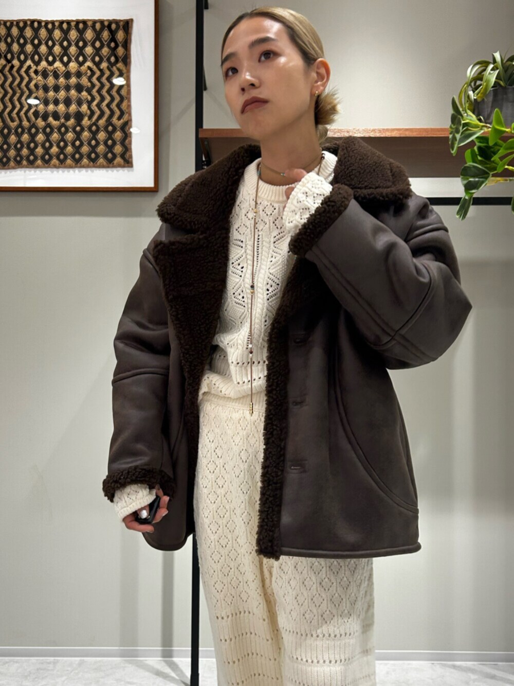 ブラウン系のブルゾン、ホワイト系のニット/セーター、グレー系のその他パンツを着用したレディースの秋コーディネートの4枚目の写真