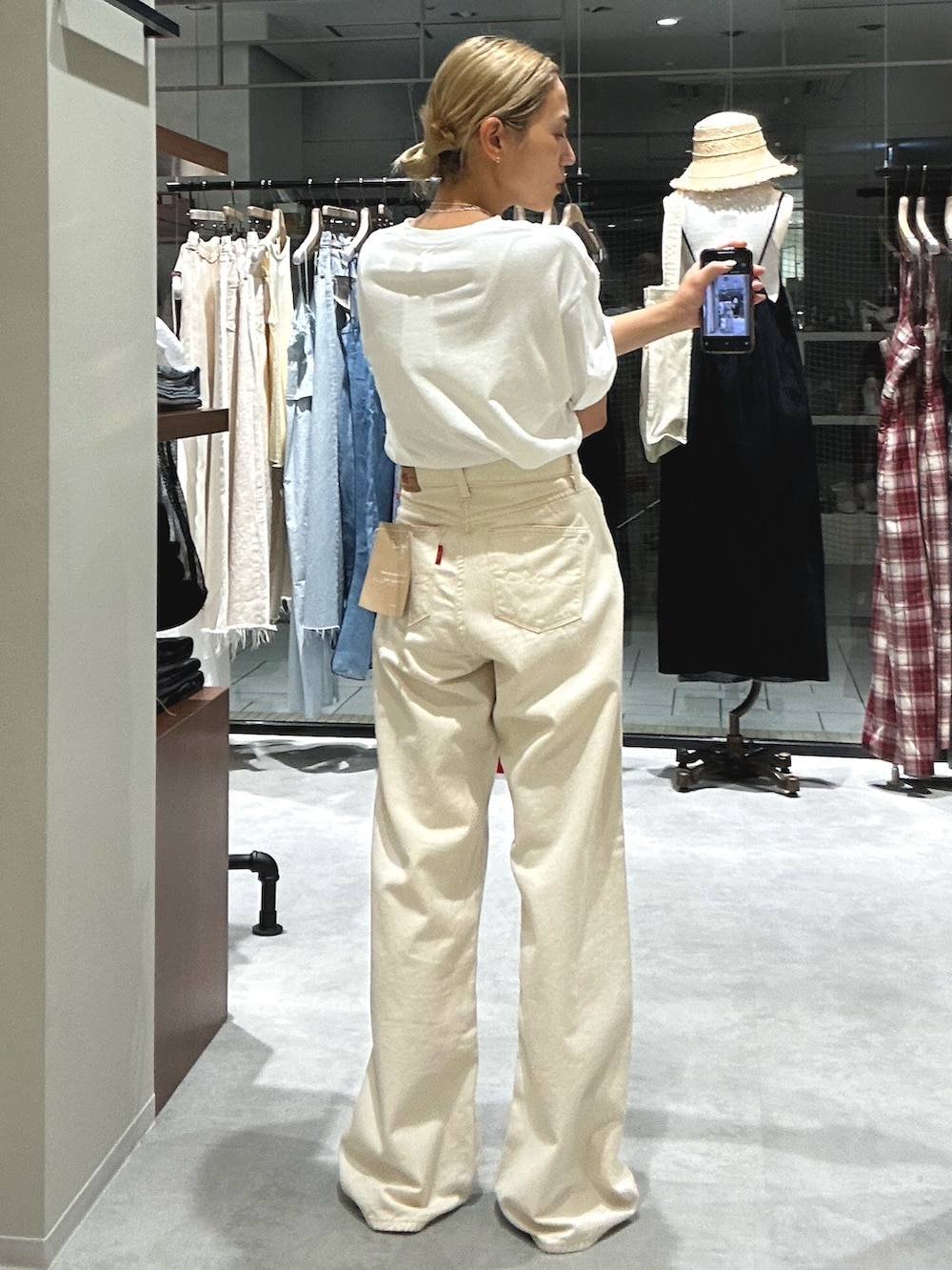 ホワイト系のデニムパンツ、ホワイト系のTシャツ/カットソー、ホワイト系のポーチを着用したレディースの夏コーディネートの3枚目の写真