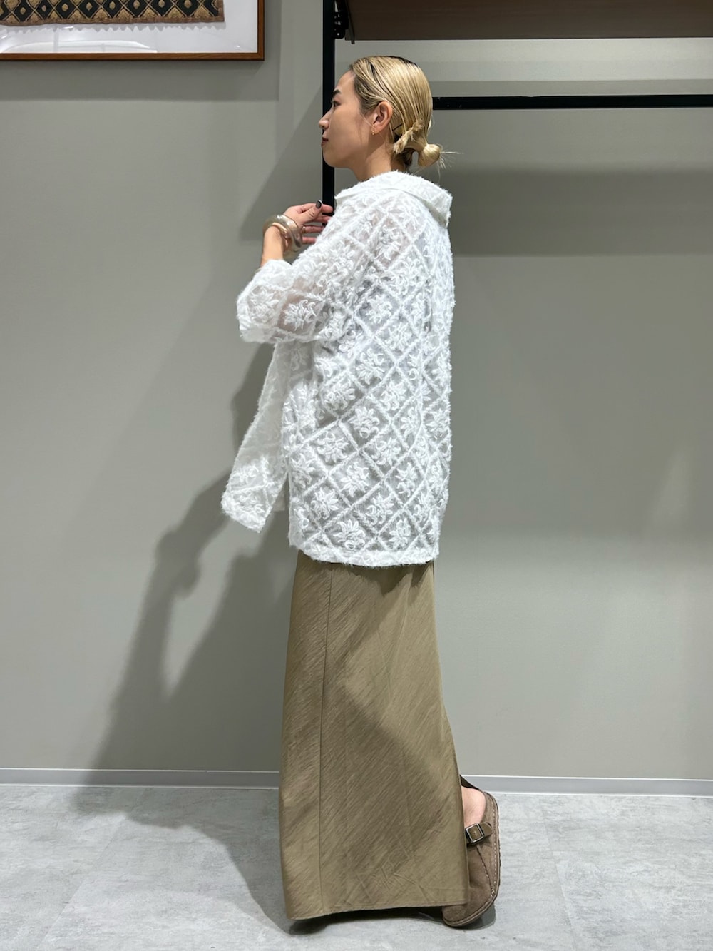 ベージュ系のスカート、ブラウン系のタンクトップ、ホワイト系のシャツ/ブラウスを着用したレディースの夏コーディネートの2枚目の写真