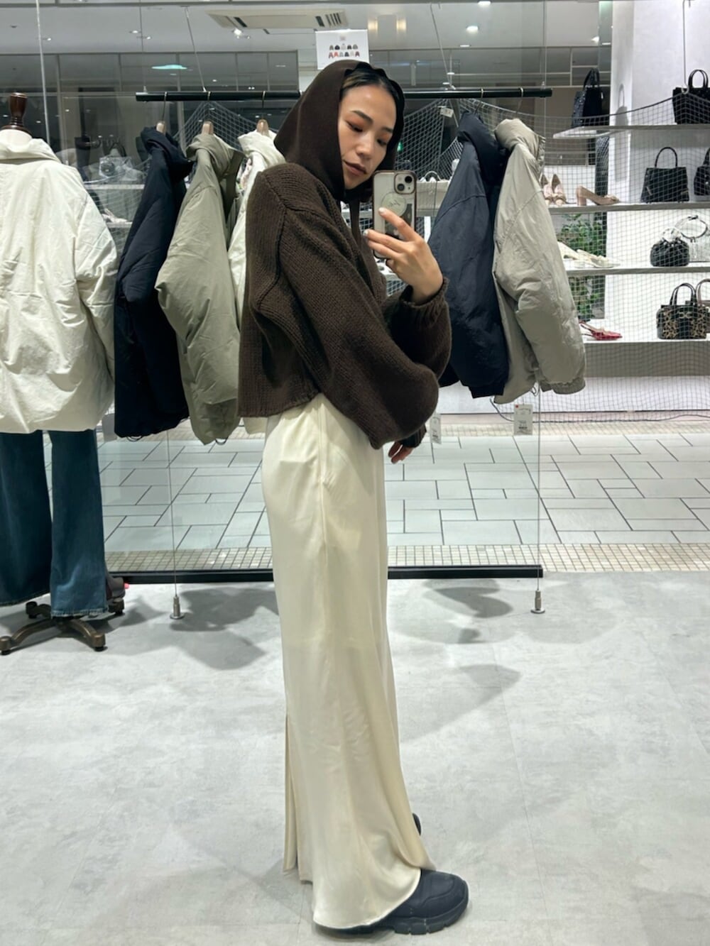 ホワイト系のスカート、ブラウン系のニット/セーター、ブラウン系の手袋を着用したレディースの冬コーディネートの2枚目の写真