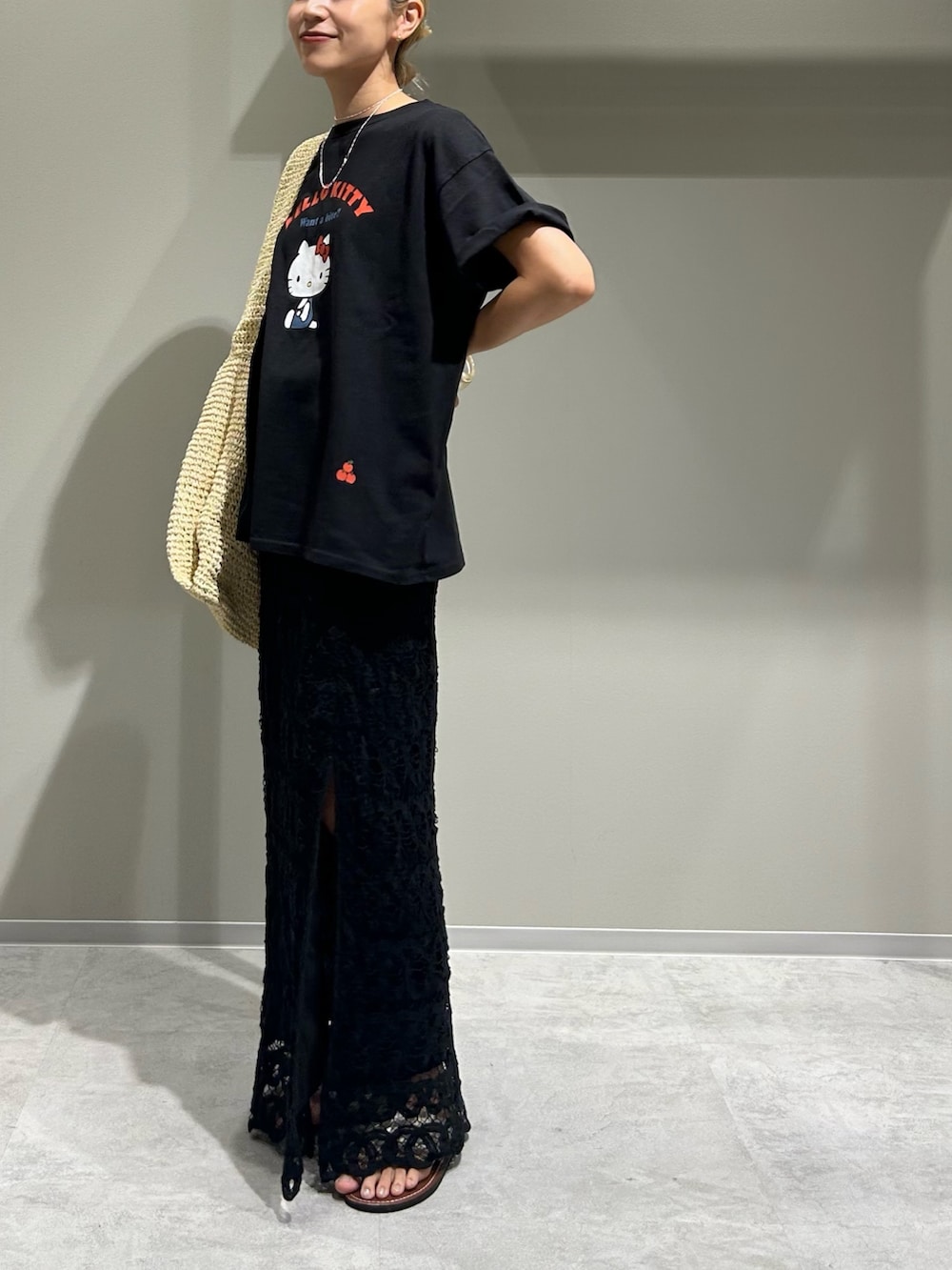 ブラック系のTシャツ/カットソー、ブラック系のスカート、ベージュ系のショルダーバッグを着用したレディースの夏コーディネートの2枚目の写真