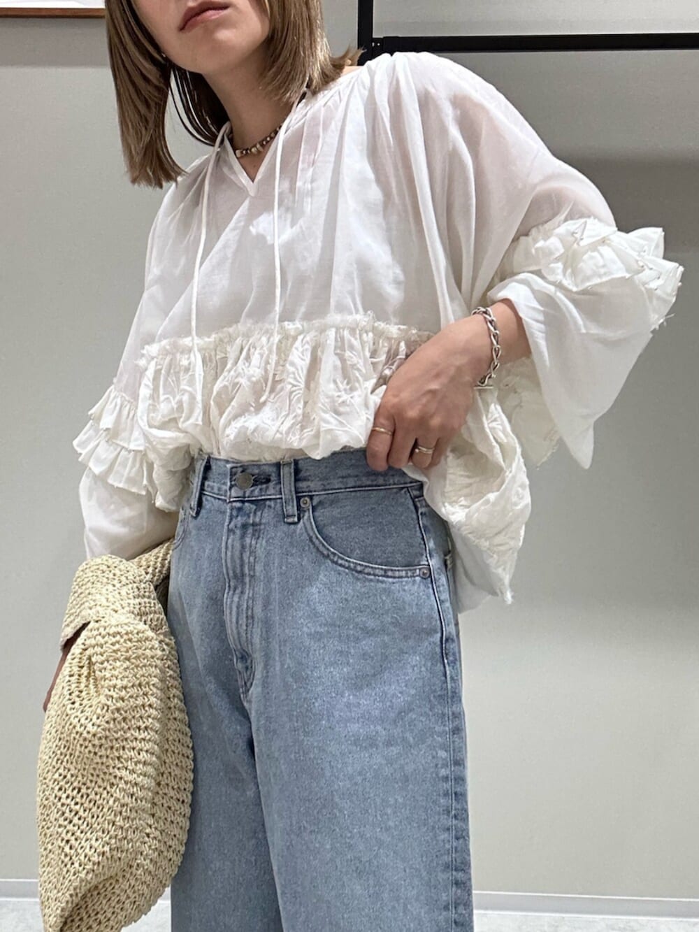 ホワイト系のシャツ/ブラウス、ブルー系のデニムパンツ、シルバー系のサンダルを着用したレディースの春コーディネートの6枚目の写真