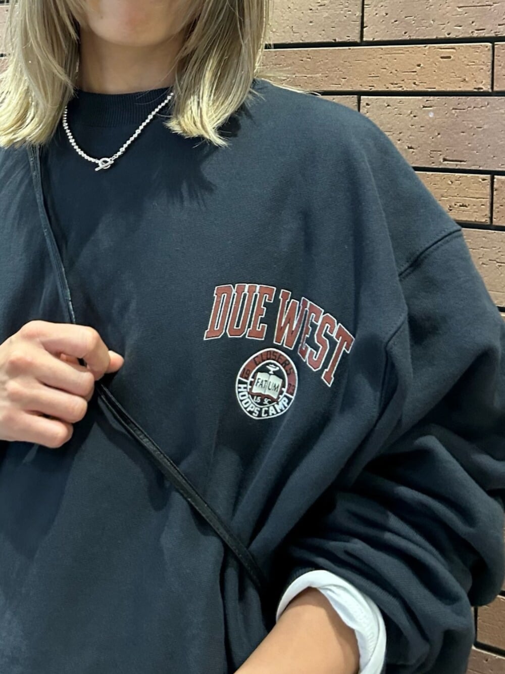 ブラック系のショルダーバッグ、グレー系のスカート、グレー系のスウェットを着用したレディースの秋コーディネートの6枚目の写真