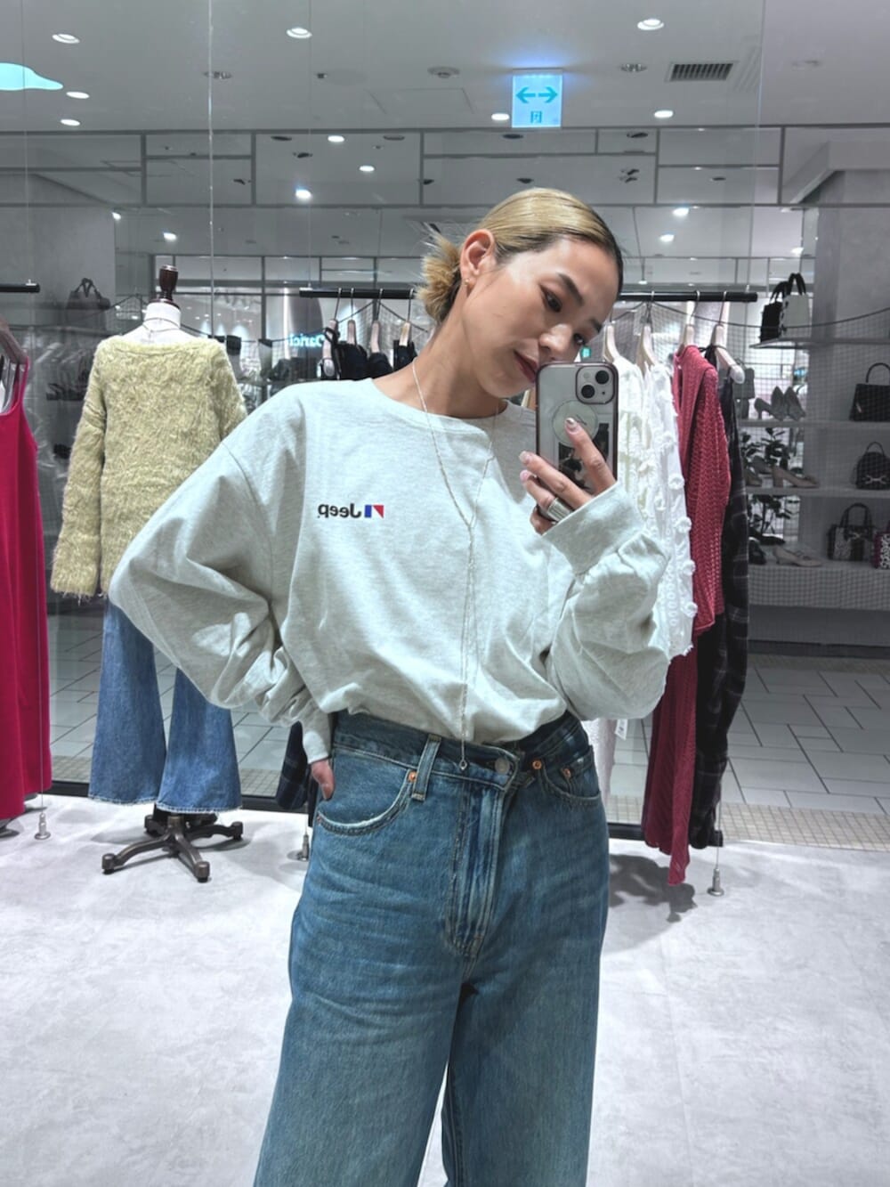 ブルー系のデニムパンツ、グレー系のTシャツ/カットソーを着用したレディースの秋コーディネートの4枚目の写真