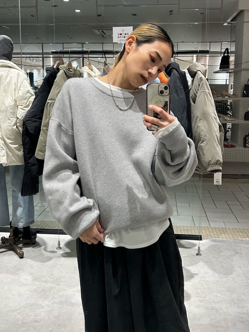 グレー系のニット/セーター、ホワイト系のTシャツ/カットソー、グレー系のその他パンツを着用したレディースの冬コーディネートの4枚目の写真