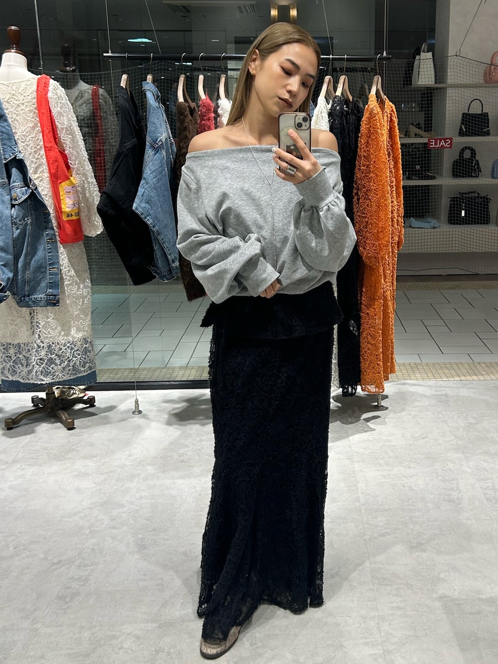 ブラック系のスカート、ホワイト系のTシャツ/カットソー、ベージュ系のローファーを着用したレディースの冬コーディネートの5枚目の写真