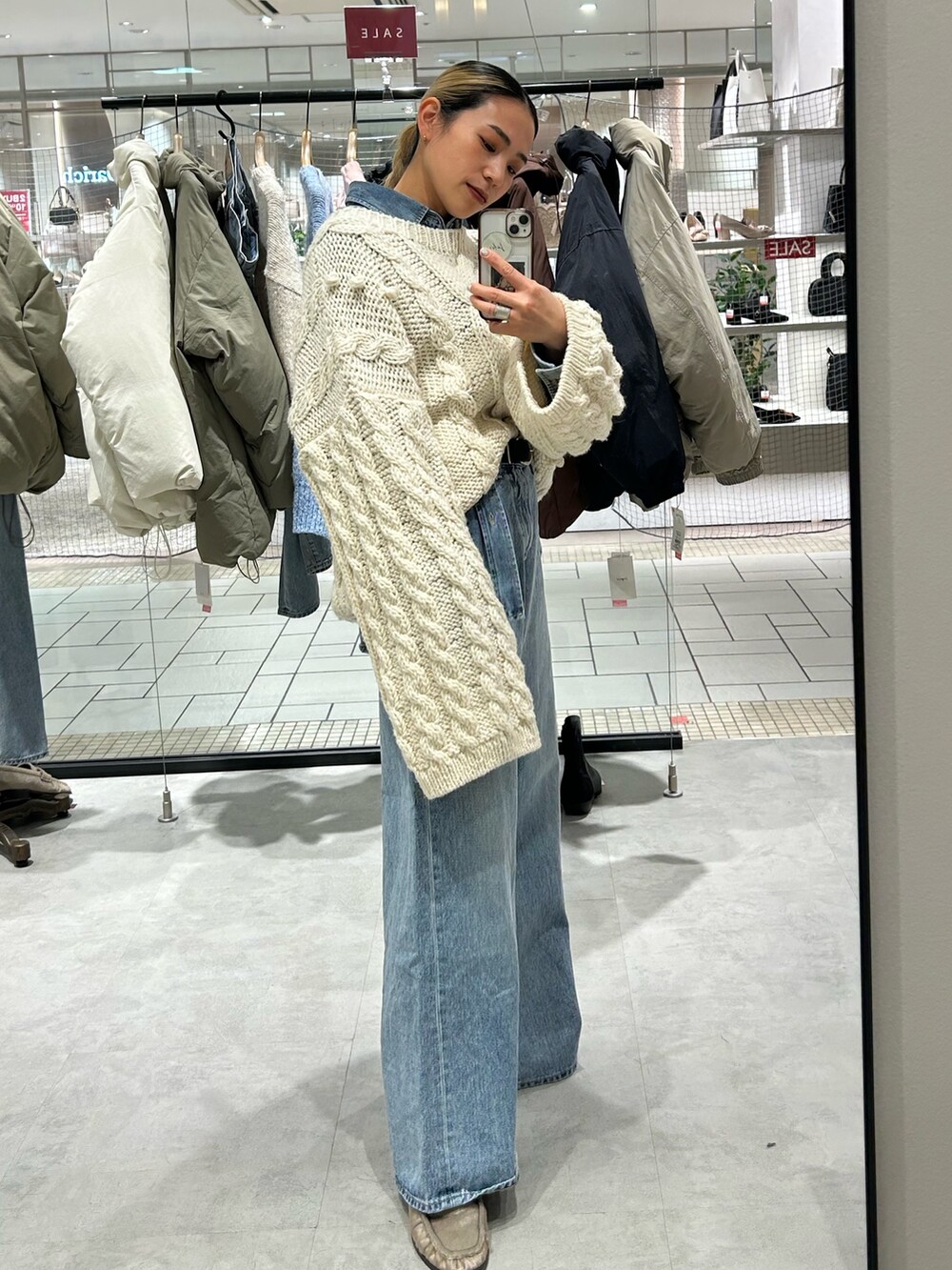 ブルー系のデニムパンツ、ブルー系のシャツ/ブラウス、ホワイト系のニット/セーターを着用したレディースの冬コーディネートの2枚目の写真