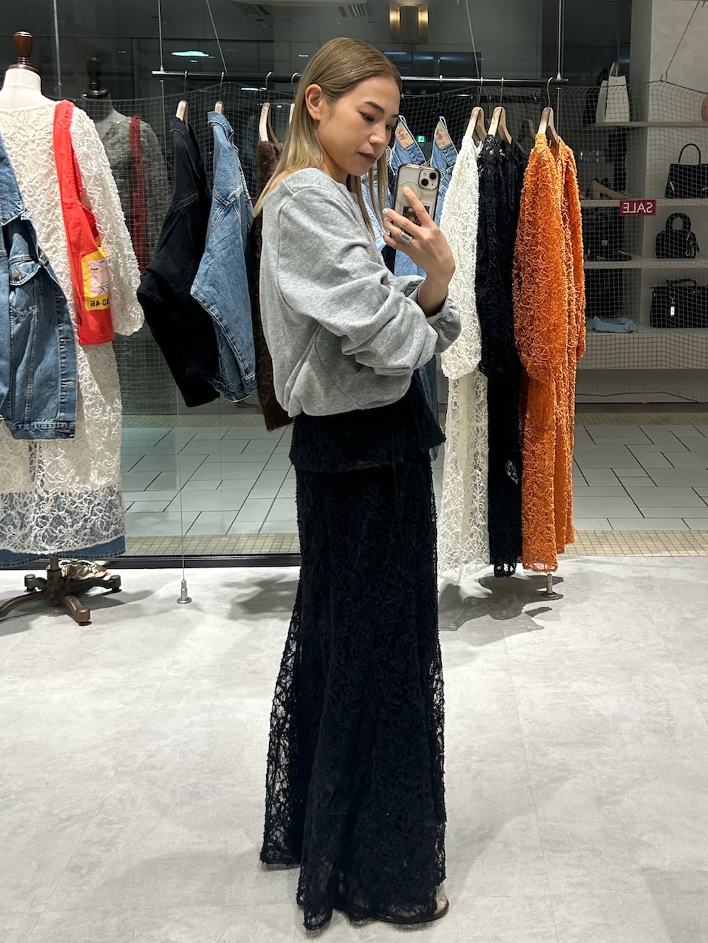 ブラック系のスカート、ホワイト系のTシャツ/カットソー、ベージュ系のローファーを着用したレディースの冬コーディネートの2枚目の写真