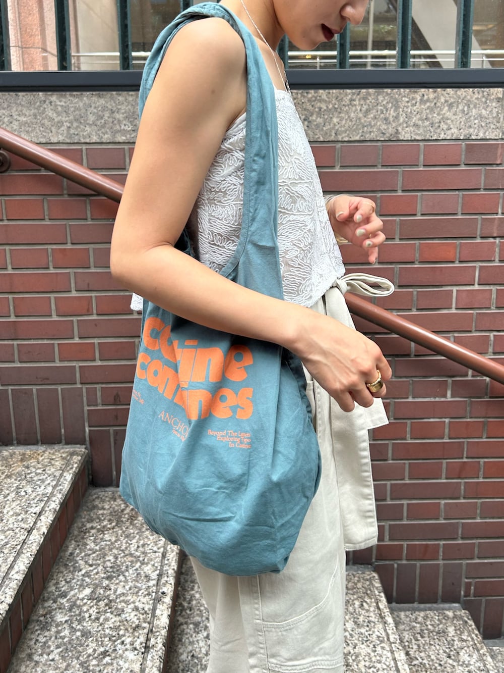 ホワイト系のその他パンツ、ホワイト系のキャミソール、ブルー系のトートバッグを着用したレディースの夏コーディネートの8枚目の写真