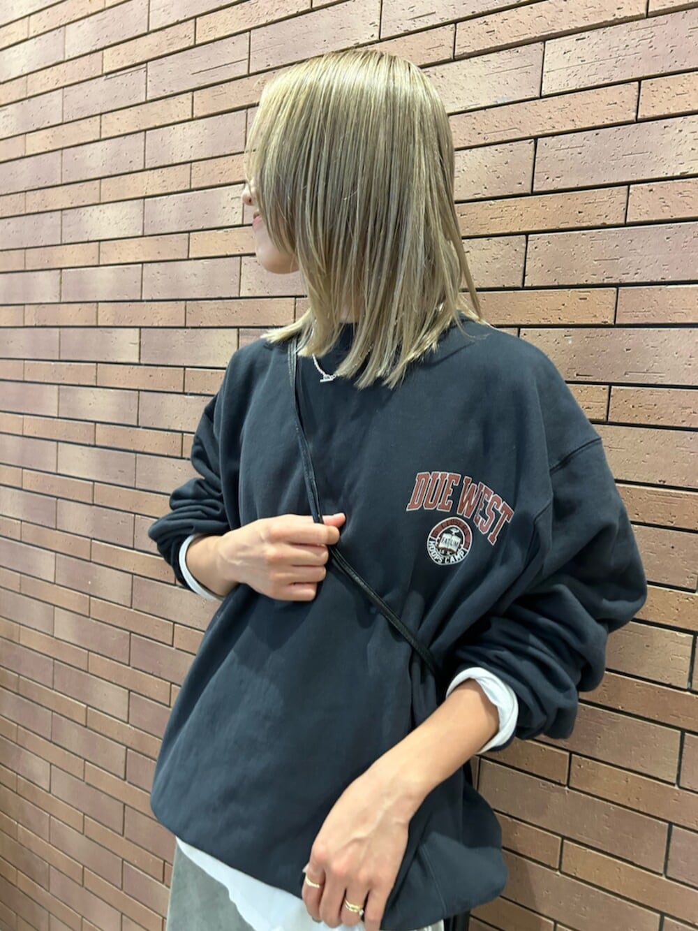 ブラック系のショルダーバッグ、グレー系のスカート、グレー系のスウェットを着用したレディースの秋コーディネートの4枚目の写真