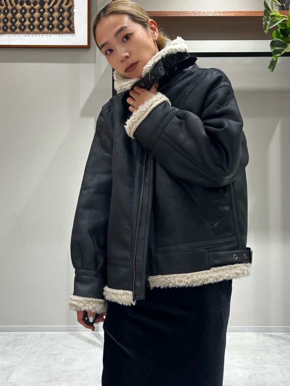 ブラック系のスカート、ブラック系のブルゾン、グレー系のキャミソールを着用したレディースの秋コーディネートの4枚目の写真