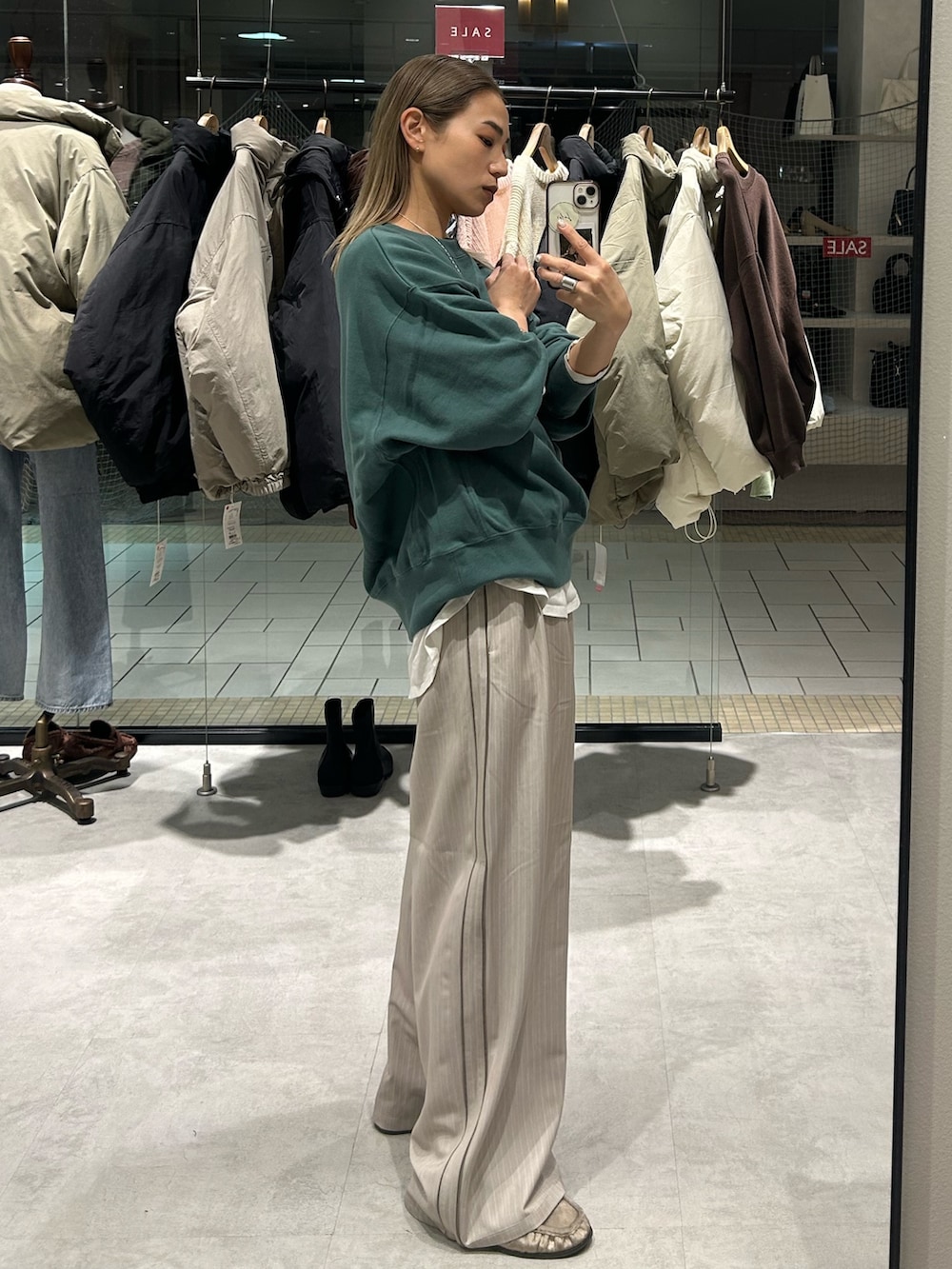 グリーン系のスウェット、ホワイト系のTシャツ/カットソー、ベージュ系のその他パンツを着用したレディースの冬コーディネートの2枚目の写真