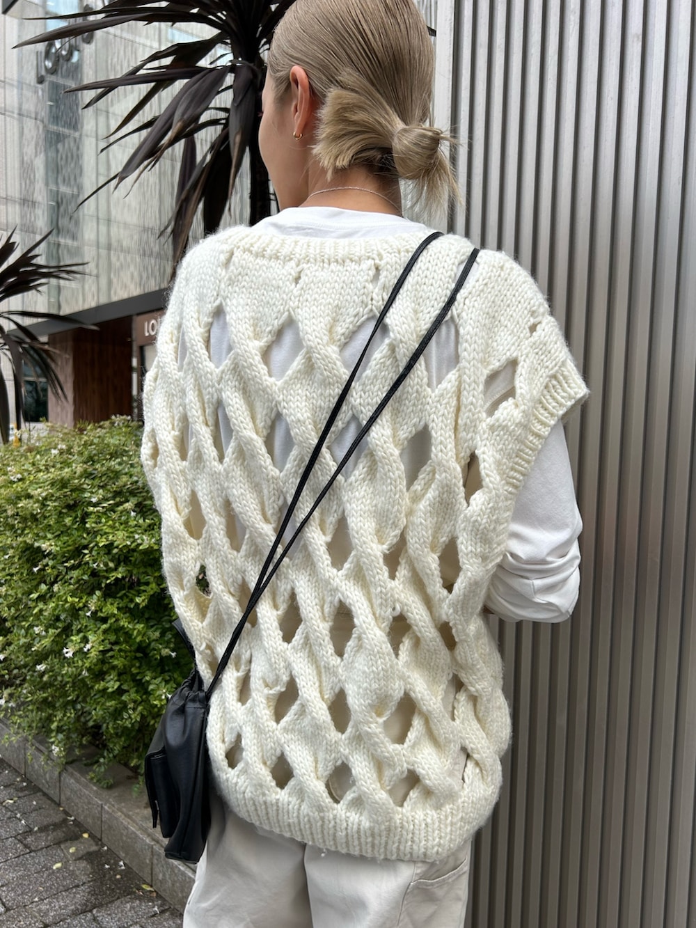 ホワイト系のその他パンツ、ホワイト系のニット/セーター、ブラック系のショルダーバッグを着用したレディースの秋コーディネートの5枚目の写真