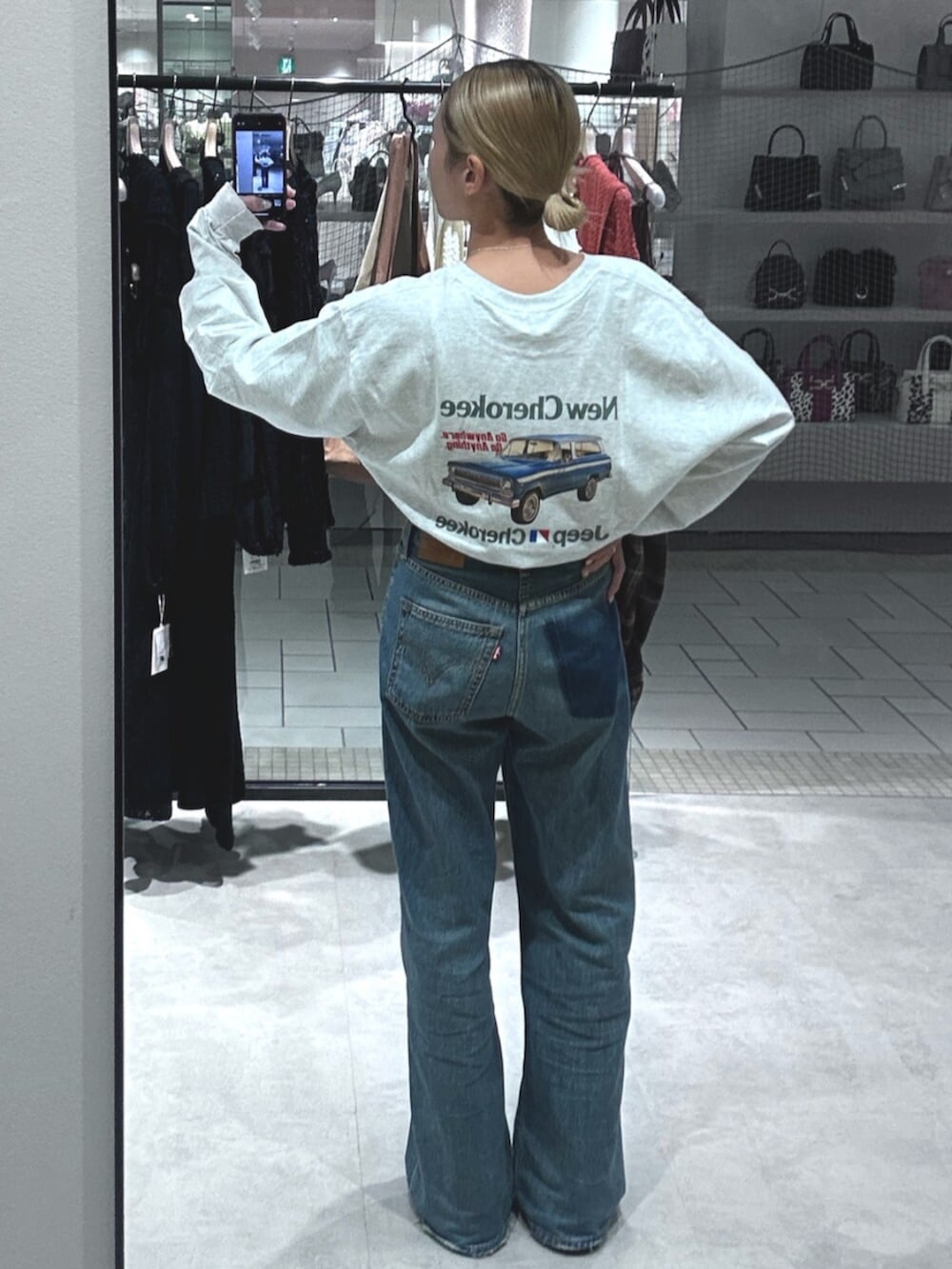 ブルー系のデニムパンツ、グレー系のTシャツ/カットソーを着用したレディースの秋コーディネートの3枚目の写真