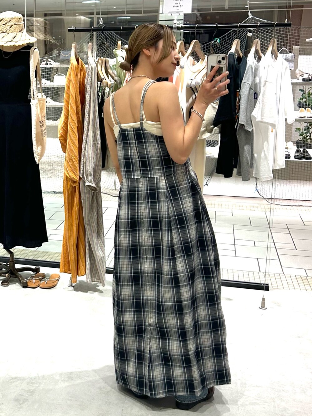 ブルー系のワンピース、ホワイト系のキャミソール、ブルー系のデニムパンツを着用したレディースの夏コーディネートの4枚目の写真