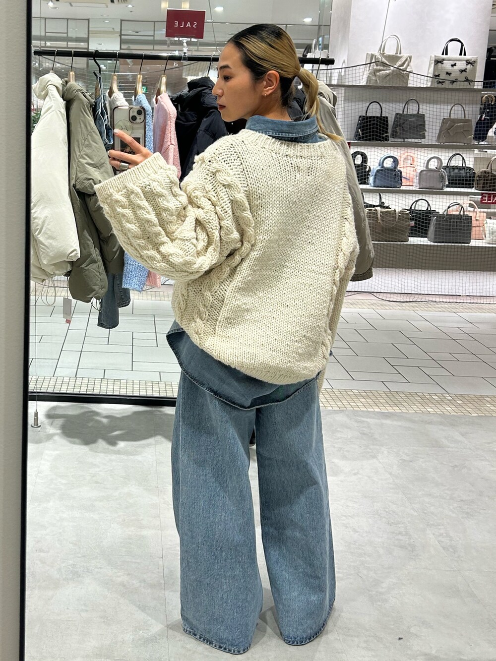 ブルー系のデニムパンツ、ブルー系のシャツ/ブラウス、ホワイト系のニット/セーターを着用したレディースの冬コーディネートの3枚目の写真