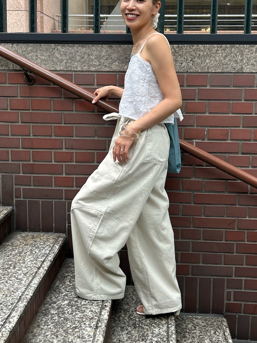 ホワイト系のその他パンツ、ホワイト系のキャミソール、ブルー系のトートバッグを着用したレディースの夏コーディネートの2枚目の写真