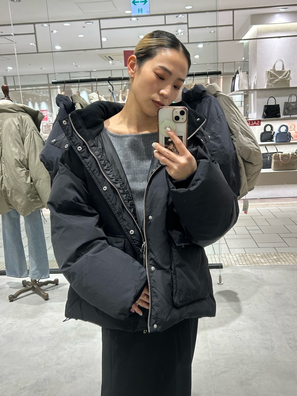 ブラック系のスカート、ブラック系のダウンジャケット/コート、グレー系のニット/セーターを着用したレディースの冬コーディネートの4枚目の写真