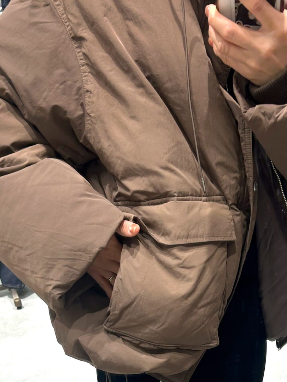 ブラック系のスカート、ベージュ系のローファー、ブラウン系のダウンジャケット/コートを着用したレディースの秋コーディネートの7枚目の写真