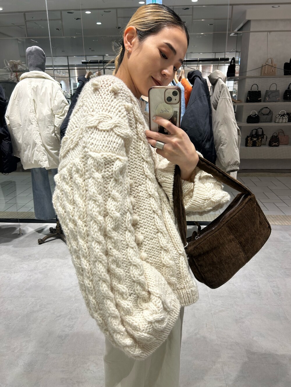 ホワイト系のニット/セーター、ホワイト系のその他パンツ、ブラウン系のハンドバッグを着用したレディースの冬コーディネートの5枚目の写真