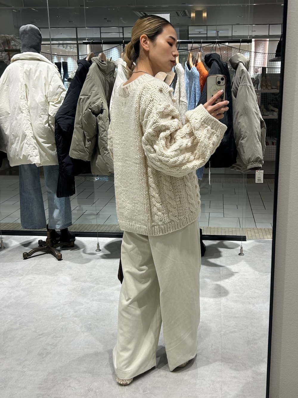 ホワイト系のニット/セーター、ホワイト系のその他パンツ、ブラウン系のハンドバッグを着用したレディースの冬コーディネートの3枚目の写真