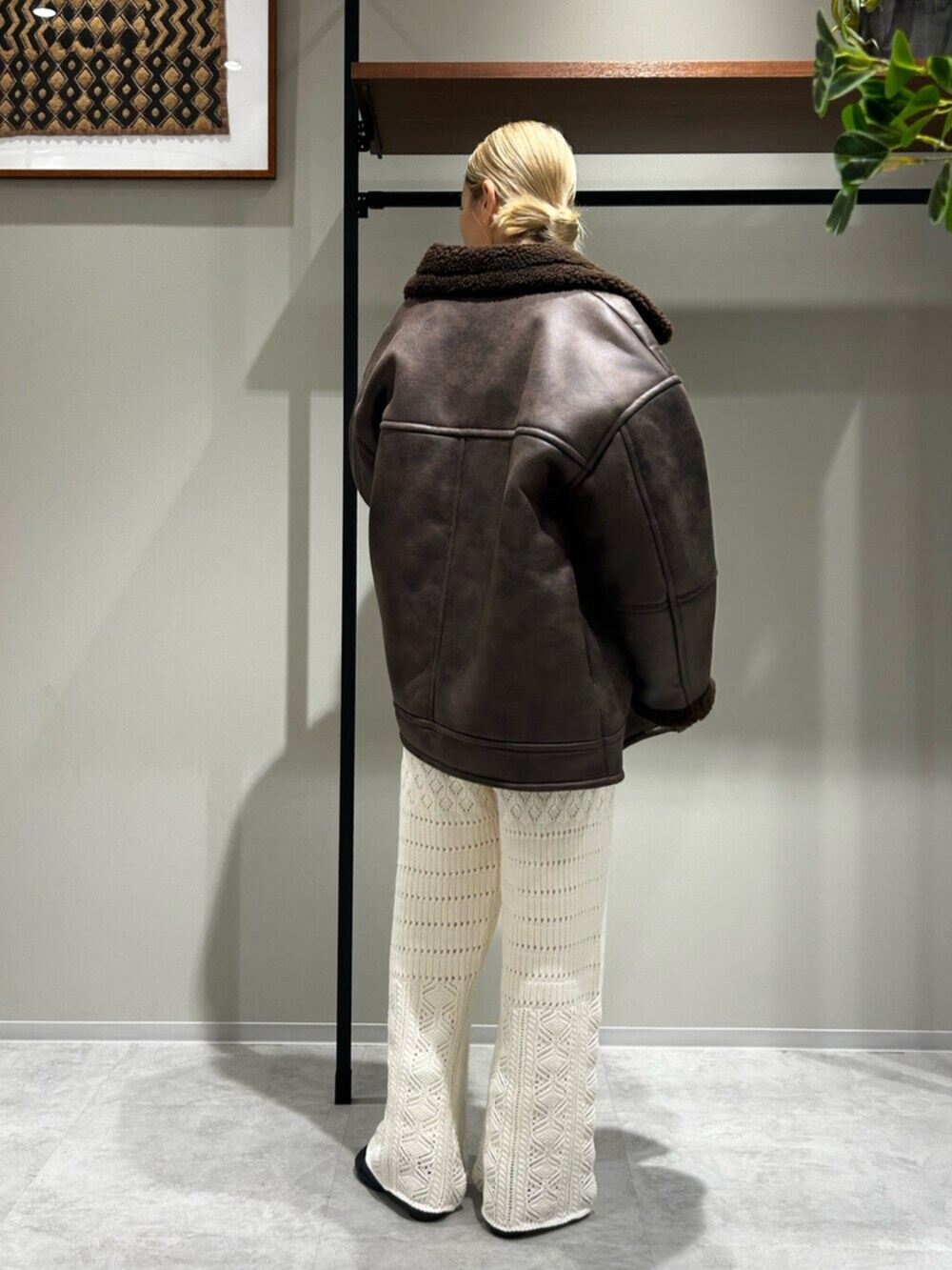 ブラウン系のブルゾン、ホワイト系のニット/セーター、グレー系のその他パンツを着用したレディースの秋コーディネートの3枚目の写真