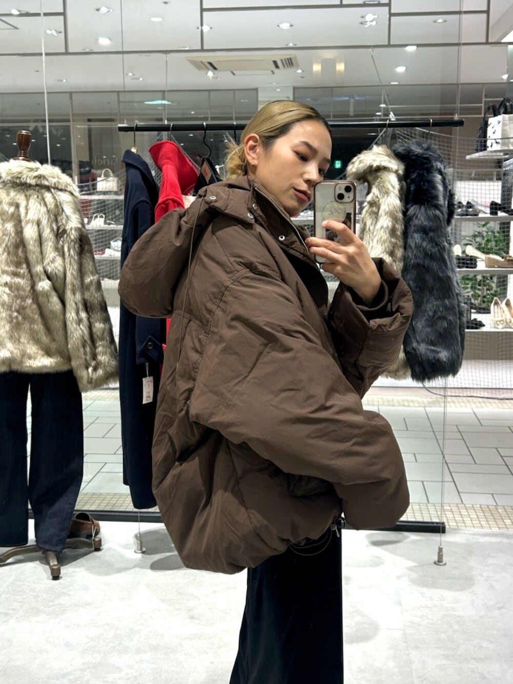 ブラック系のスカート、ベージュ系のローファー、ブラウン系のダウンジャケット/コートを着用したレディースの秋コーディネートの5枚目の写真