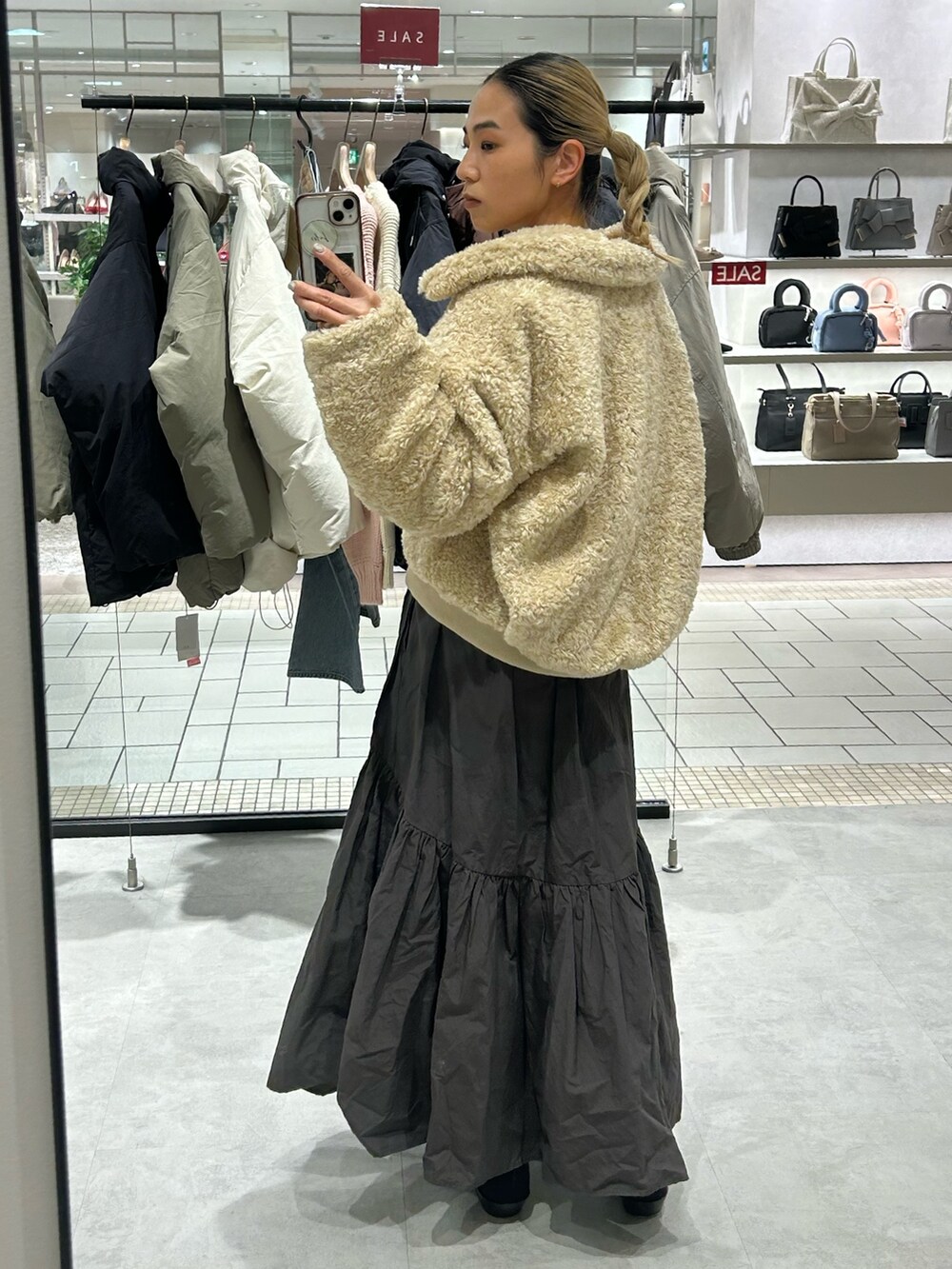 ホワイト系のブルゾン、グレー系のスカート、グレー系のニット/セーターを着用したレディースの冬コーディネートの3枚目の写真