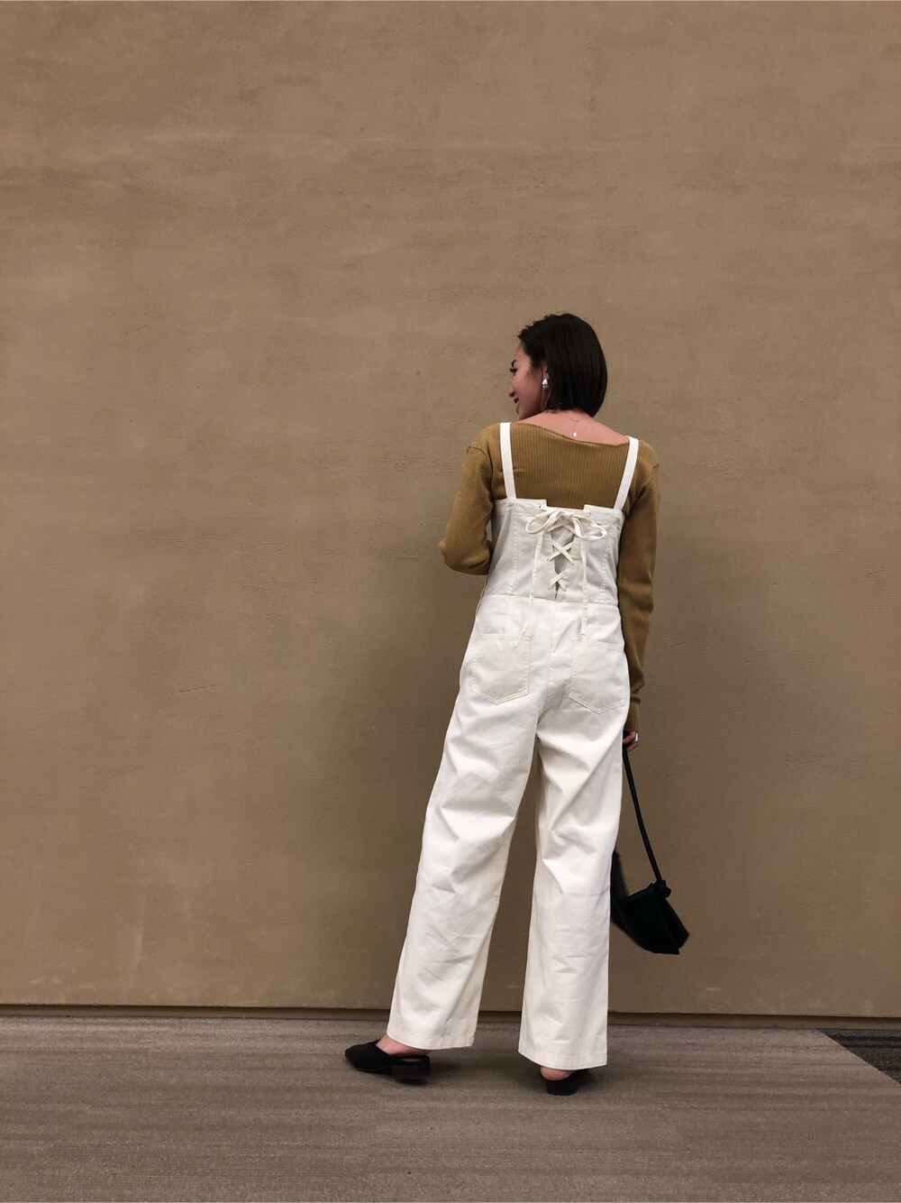 ブラック系のその他シューズ、ブラック系のショルダーバッグ、イエロー系のニット/セーターを着用したレディースの春コーディネートの2枚目の写真