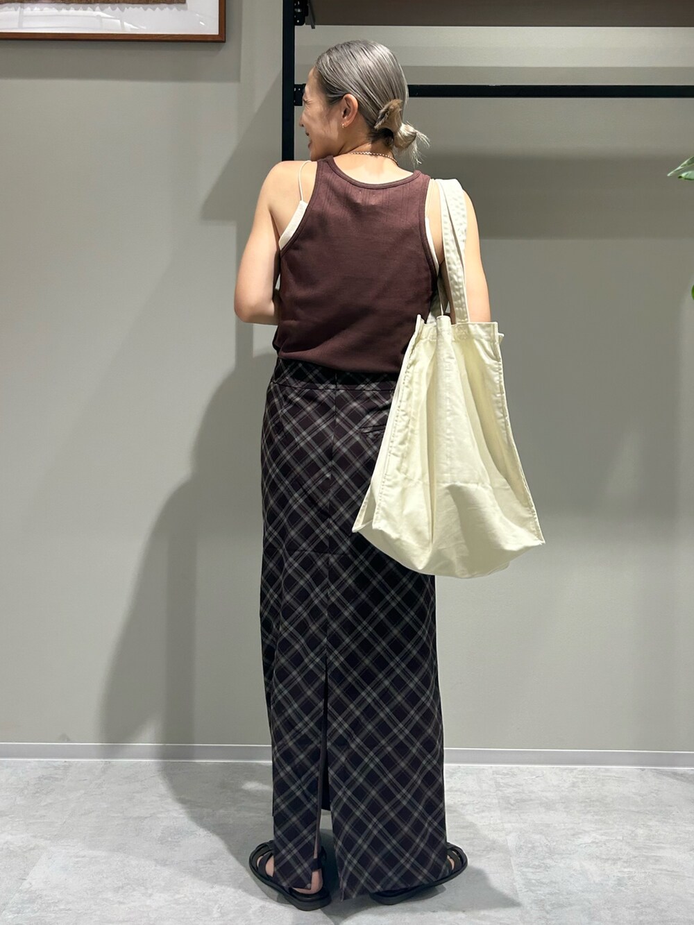 ブラウン系のスカート、ブラウン系のタンクトップ、ホワイト系のトートバッグを着用したレディースの夏コーディネートの2枚目の写真