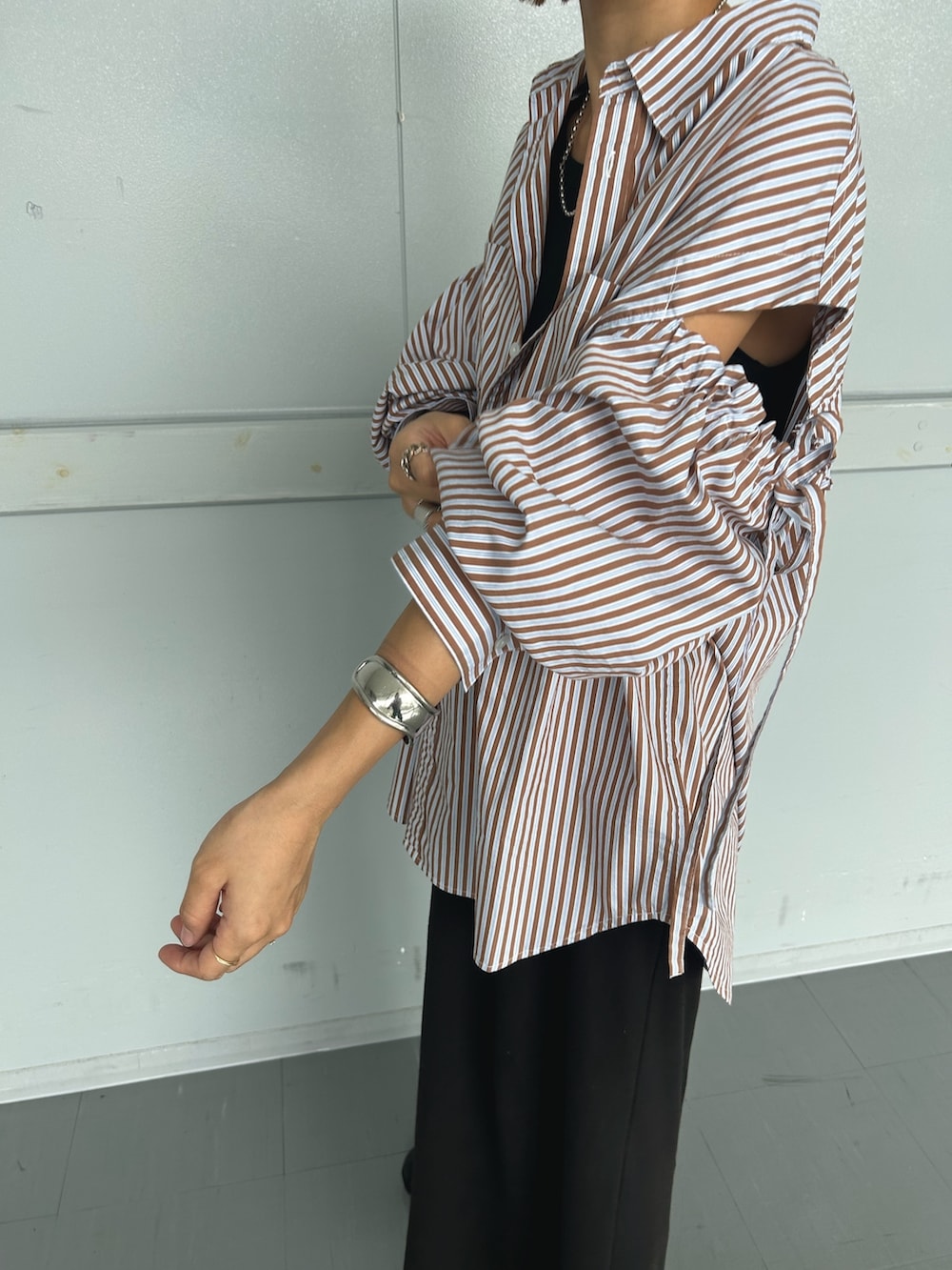 ブラウン系のシャツ/ブラウス、ブラック系のワンピース、ブラック系のブーツを着用したレディースの秋コーディネートの3枚目の写真