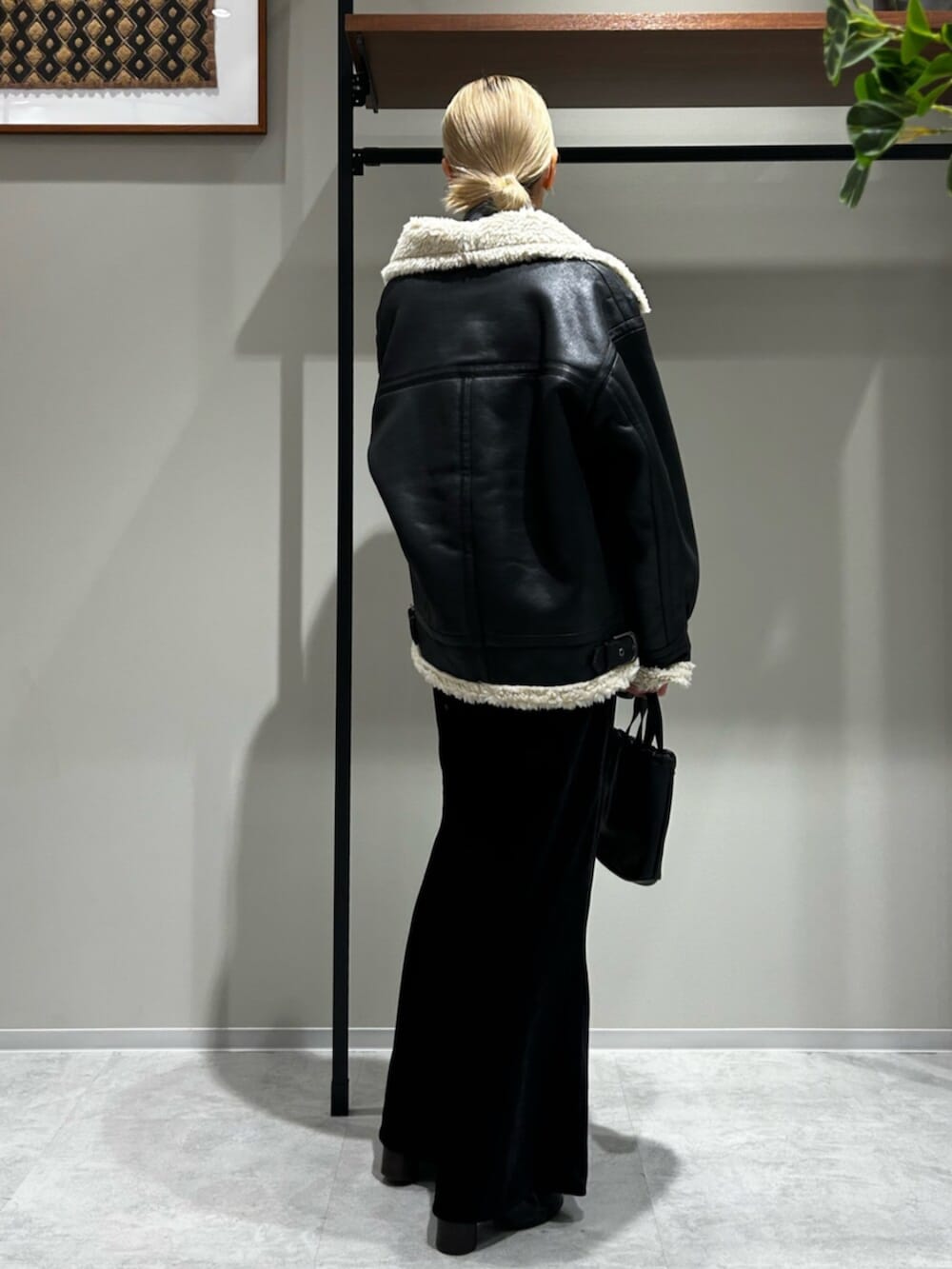 ブラック系のスカート、ブラック系のブルゾン、グレー系のキャミソールを着用したレディースの秋コーディネートの3枚目の写真