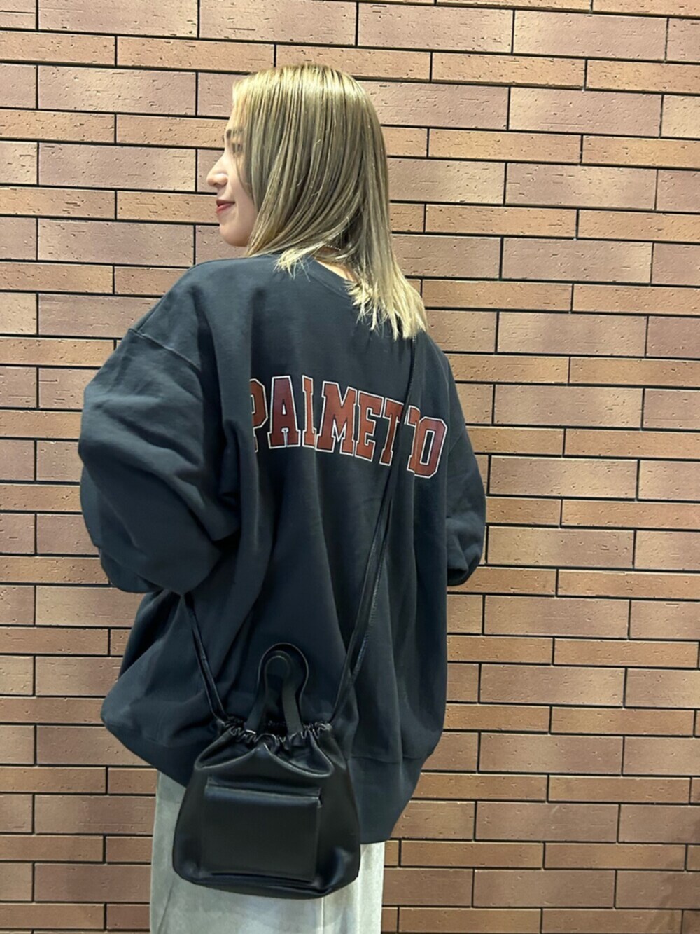 ブラック系のショルダーバッグ、グレー系のスカート、グレー系のスウェットを着用したレディースの秋コーディネートの5枚目の写真