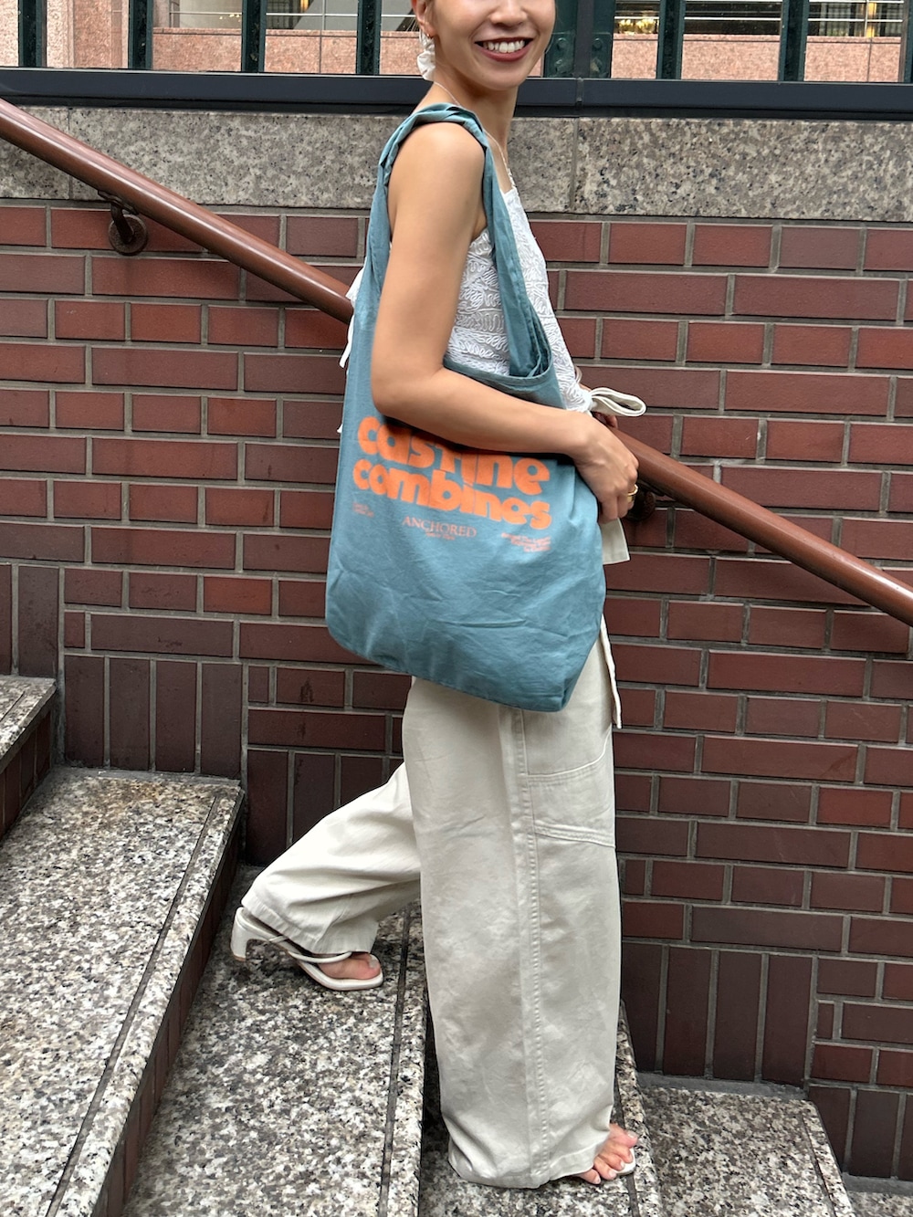 ホワイト系のその他パンツ、ホワイト系のキャミソール、ブルー系のトートバッグを着用したレディースの夏コーディネートの4枚目の写真