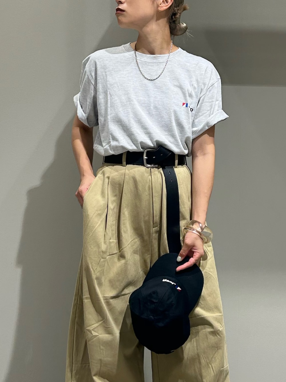 ベージュ系のチノパンツ、グレー系のTシャツ/カットソー、ブラック系のハンドバッグを着用したレディースの夏コーディネートの4枚目の写真