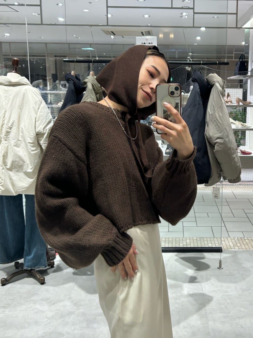 ホワイト系のスカート、ブラウン系のニット/セーター、ブラウン系の手袋を着用したレディースの冬コーディネートの4枚目の写真