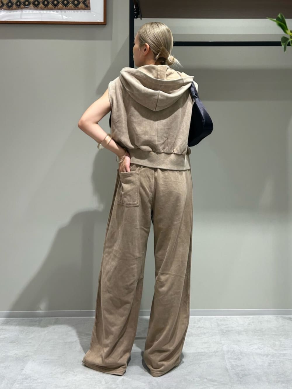 ブラック系のハンドバッグ、ベージュ系のパーカー、ベージュ系のスウェットパンツを着用したレディースの夏コーディネートの3枚目の写真