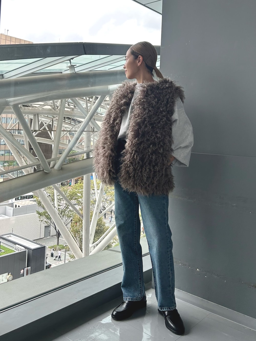 グレー系のスウェット、グレー系のベストを着用したレディースの秋コーディネートの2枚目の写真