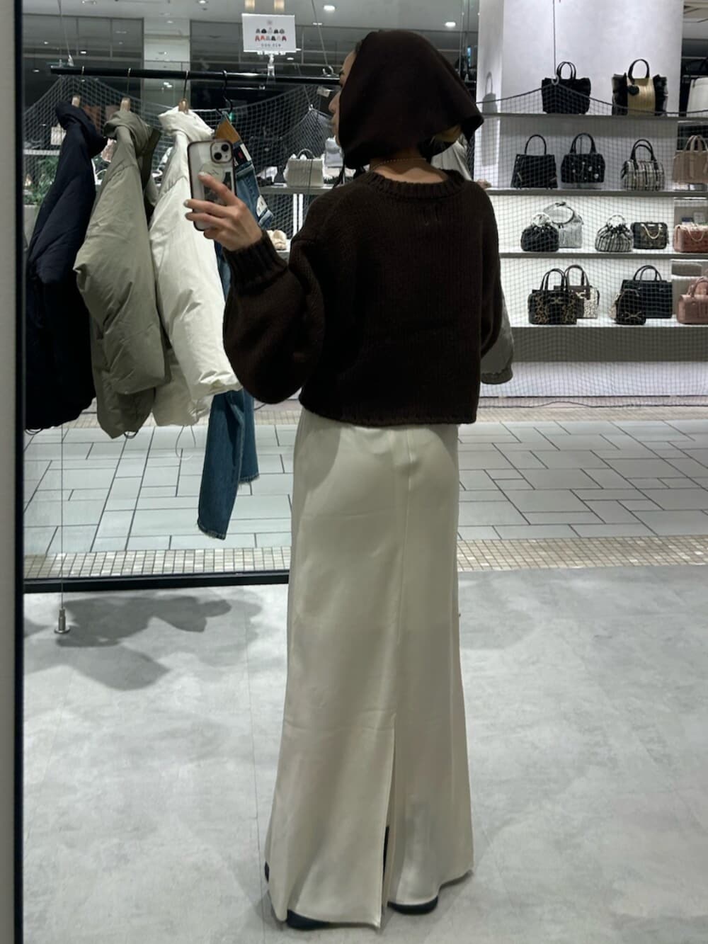 ホワイト系のスカート、ブラウン系のニット/セーター、ブラウン系の手袋を着用したレディースの冬コーディネートの3枚目の写真