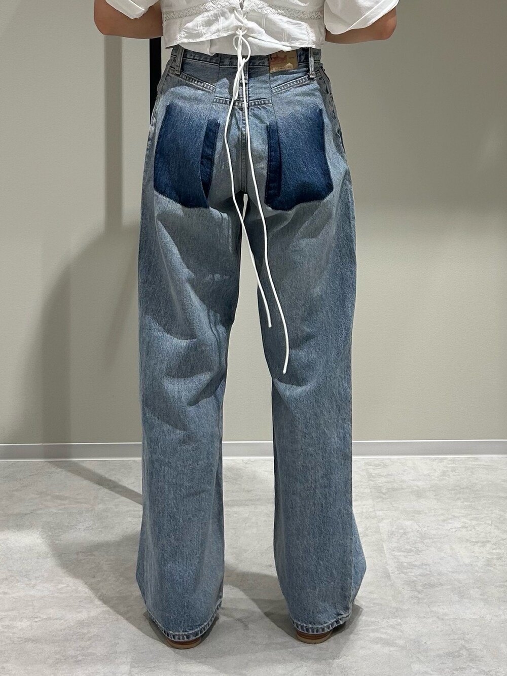 ブルー系のデニムパンツ、ホワイト系のキャミソール、ホワイト系のTシャツ/カットソーを着用したレディースの春コーディネートの6枚目の写真