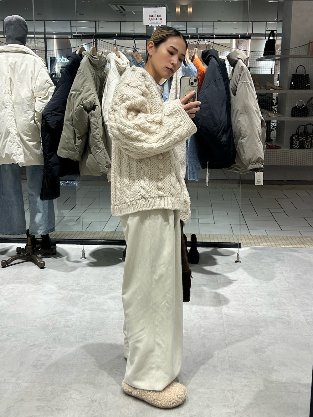 ホワイト系のニット/セーター、ホワイト系のその他パンツ、ブラウン系のハンドバッグを着用したレディースの冬コーディネートの2枚目の写真