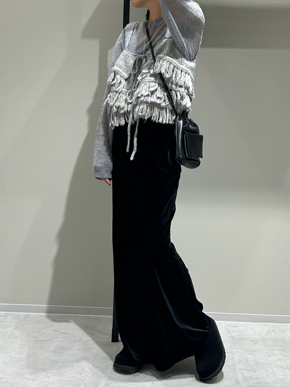 ブラック系のスカート、グレー系のニット/セーター、ブルー系のニット/セーターを着用したレディースの秋コーディネートの4枚目の写真