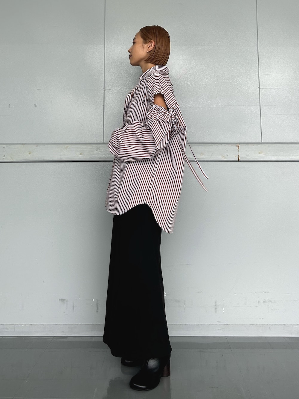 ブラウン系のシャツ/ブラウス、ブラック系のワンピース、ブラック系のブーツを着用したレディースの秋コーディネートの2枚目の写真