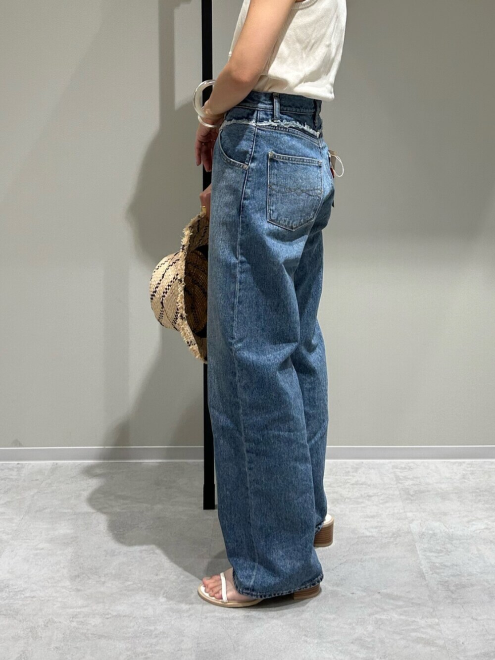 ホワイト系のサンダル、ブルー系のデニムパンツ、ホワイト系のタンクトップを着用したレディースの夏コーディネートの7枚目の写真