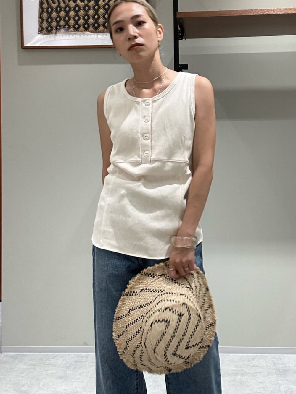 ホワイト系のサンダル、ブルー系のデニムパンツ、ホワイト系のタンクトップを着用したレディースの夏コーディネートの4枚目の写真