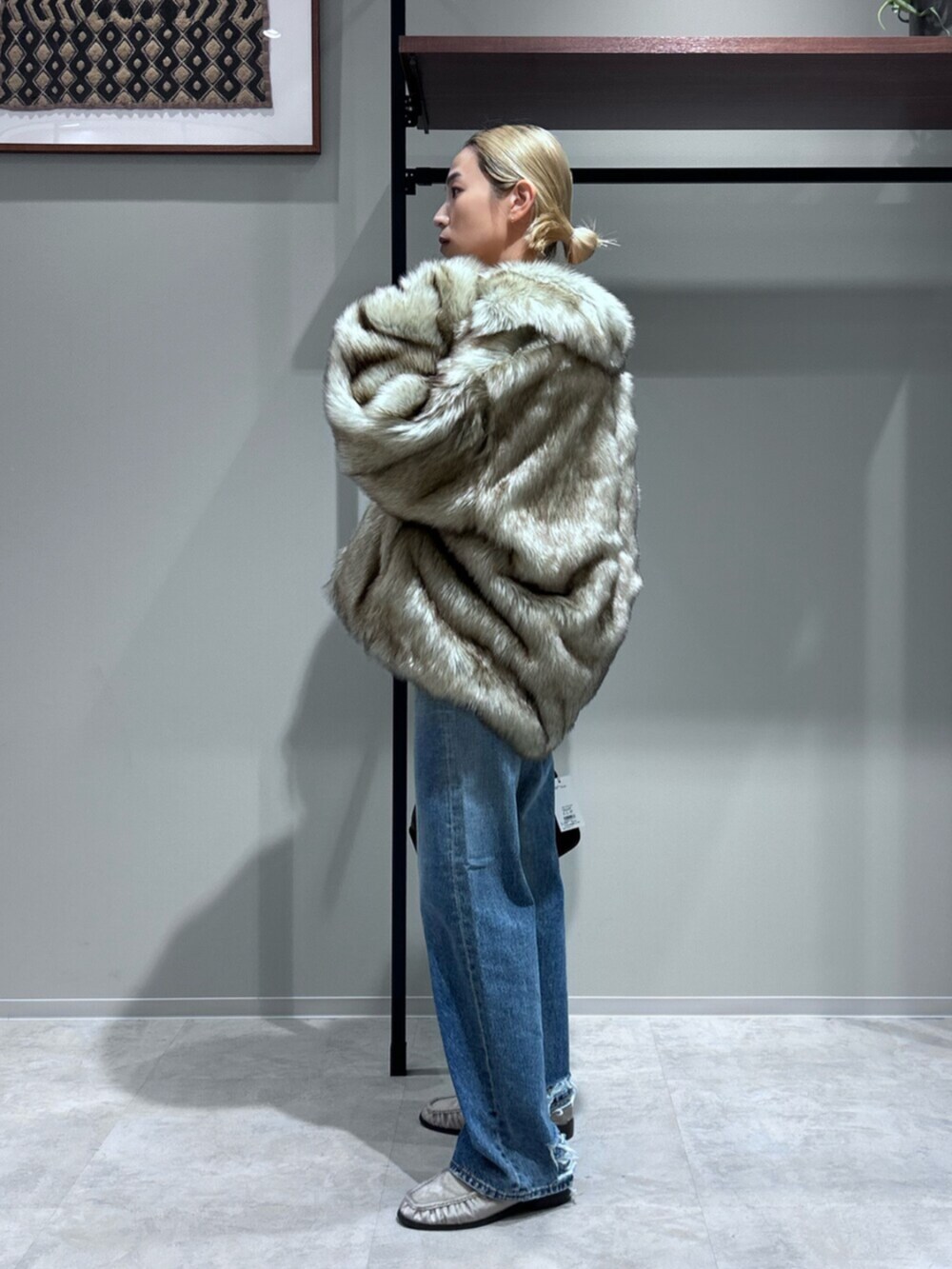 グレー系のスウェット、ベージュ系のローファー、ベージュ系のダウンジャケット/コートを着用したレディースの秋コーディネートの2枚目の写真